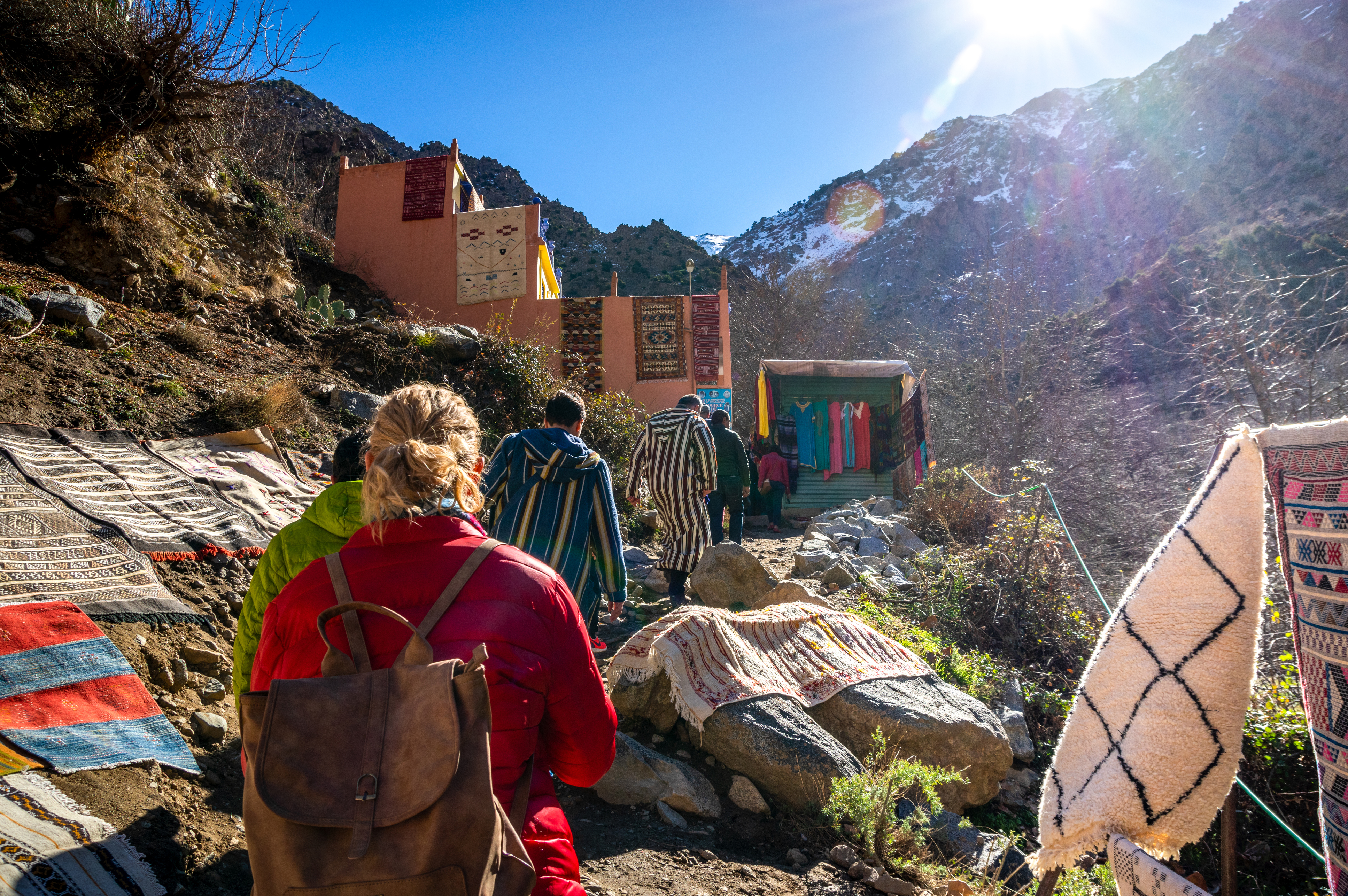 A small group of hikers follow a mountain path