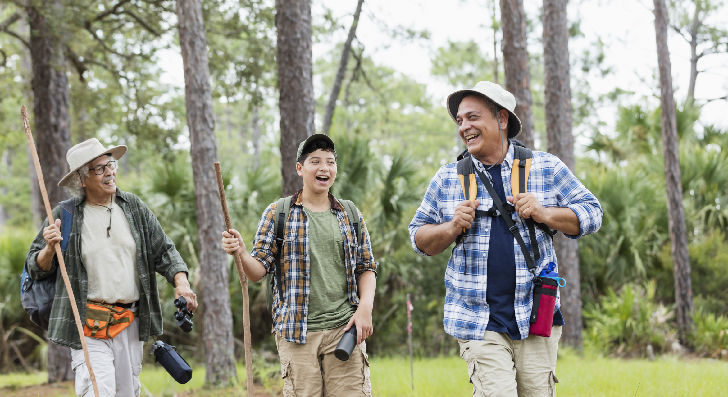 A multi-generation Hispanic family hiking together outdoors in the woods in Florida