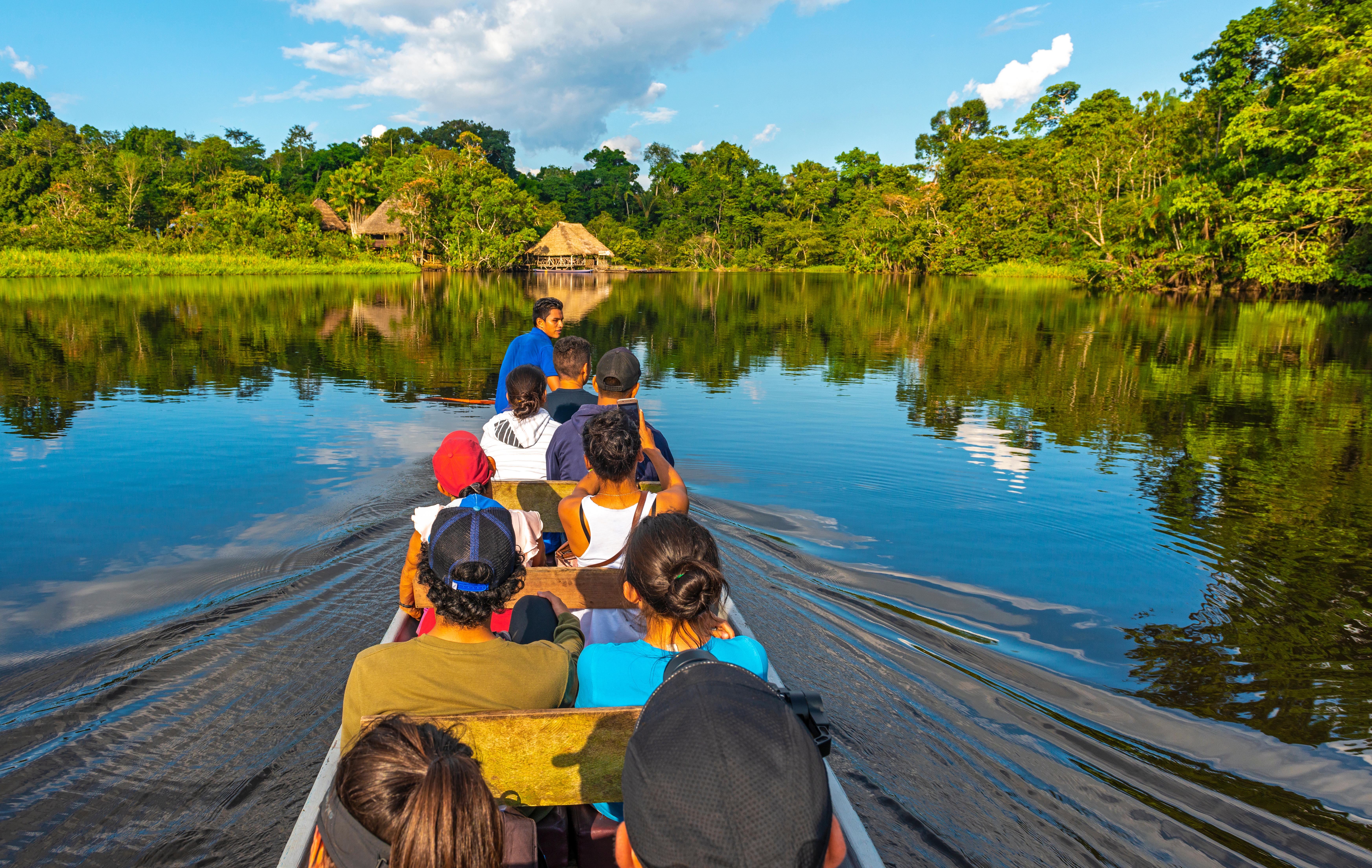 best ecuador amazon tours Passengers in a traditional canoe along the rivers of the Amazon River Basin inside Yasuní National Park, Ecuador, South America