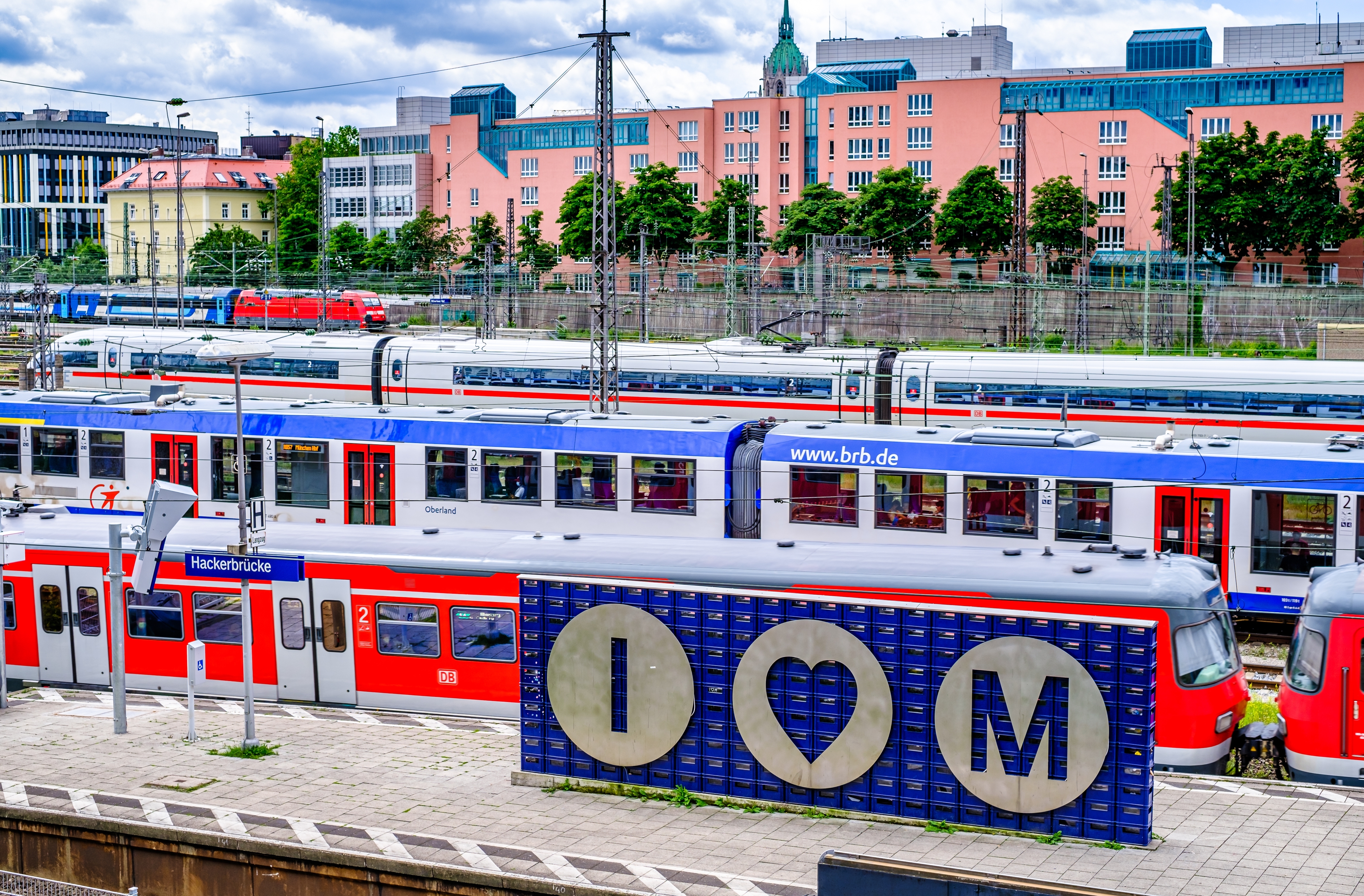 A sign saying "I heart M" at a busy train station