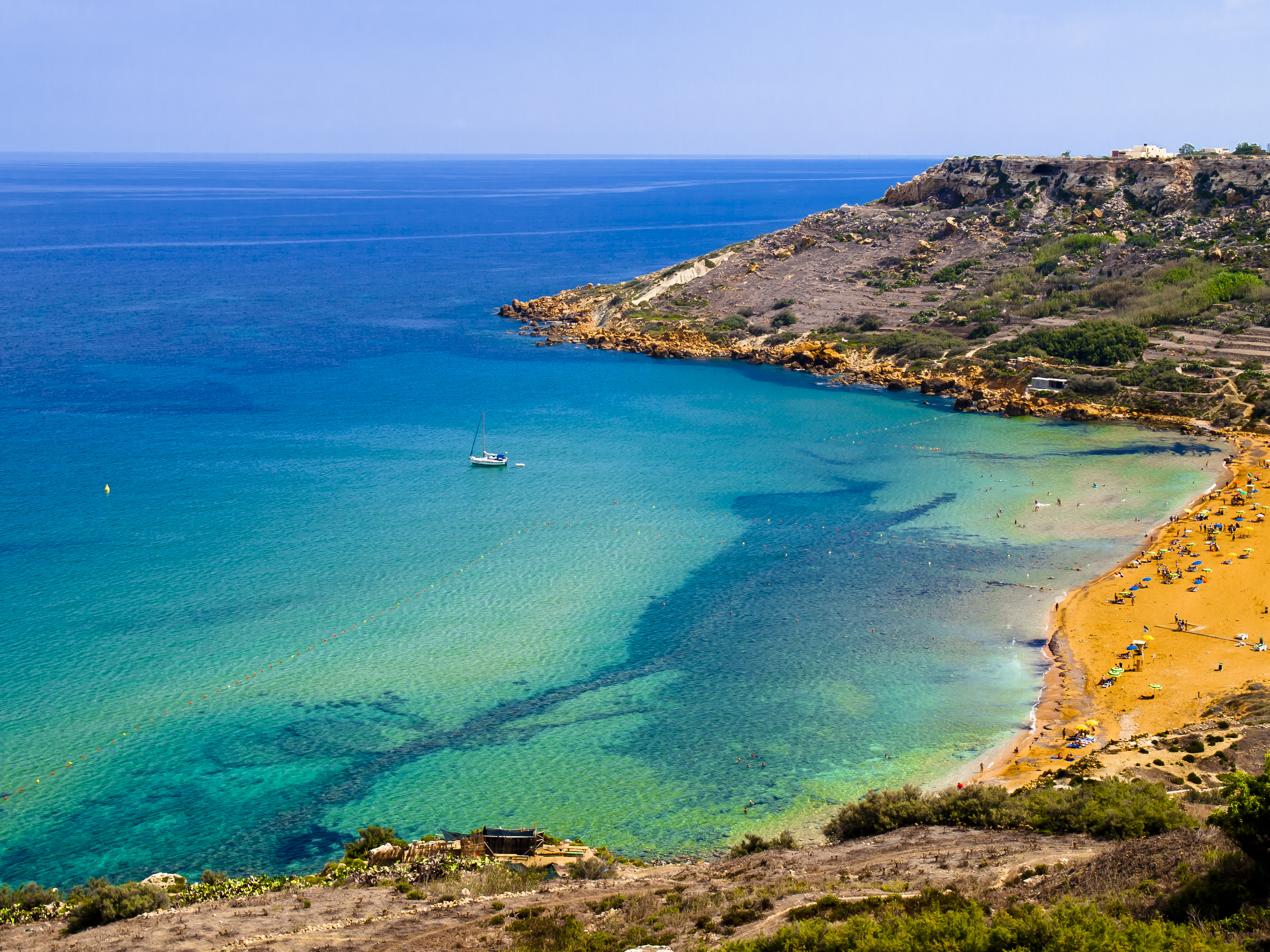 An orange-sand bay on the edge of turquoise ocean