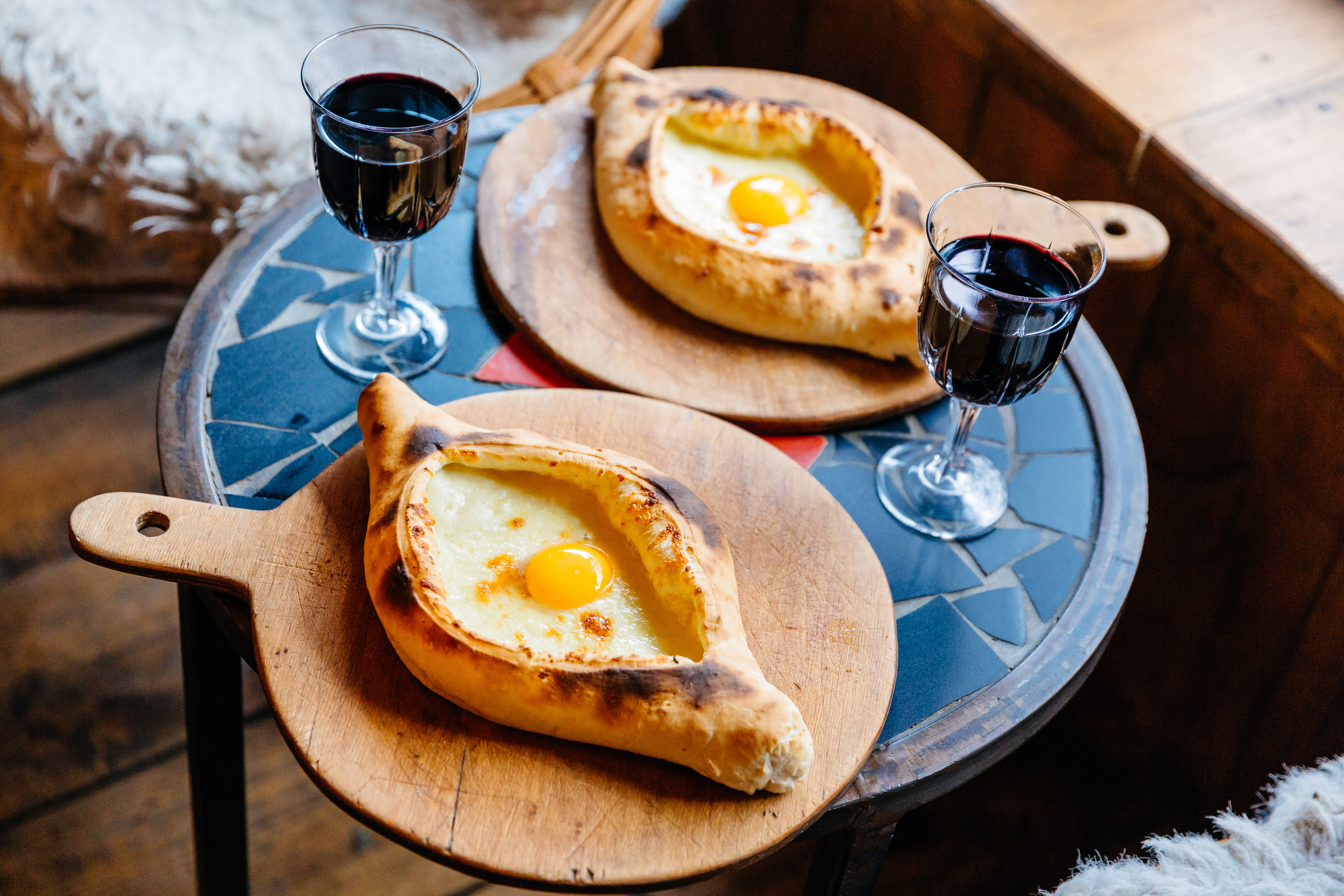 A table with Khachapuri and red wine in Tbilisi, Georgia. 
