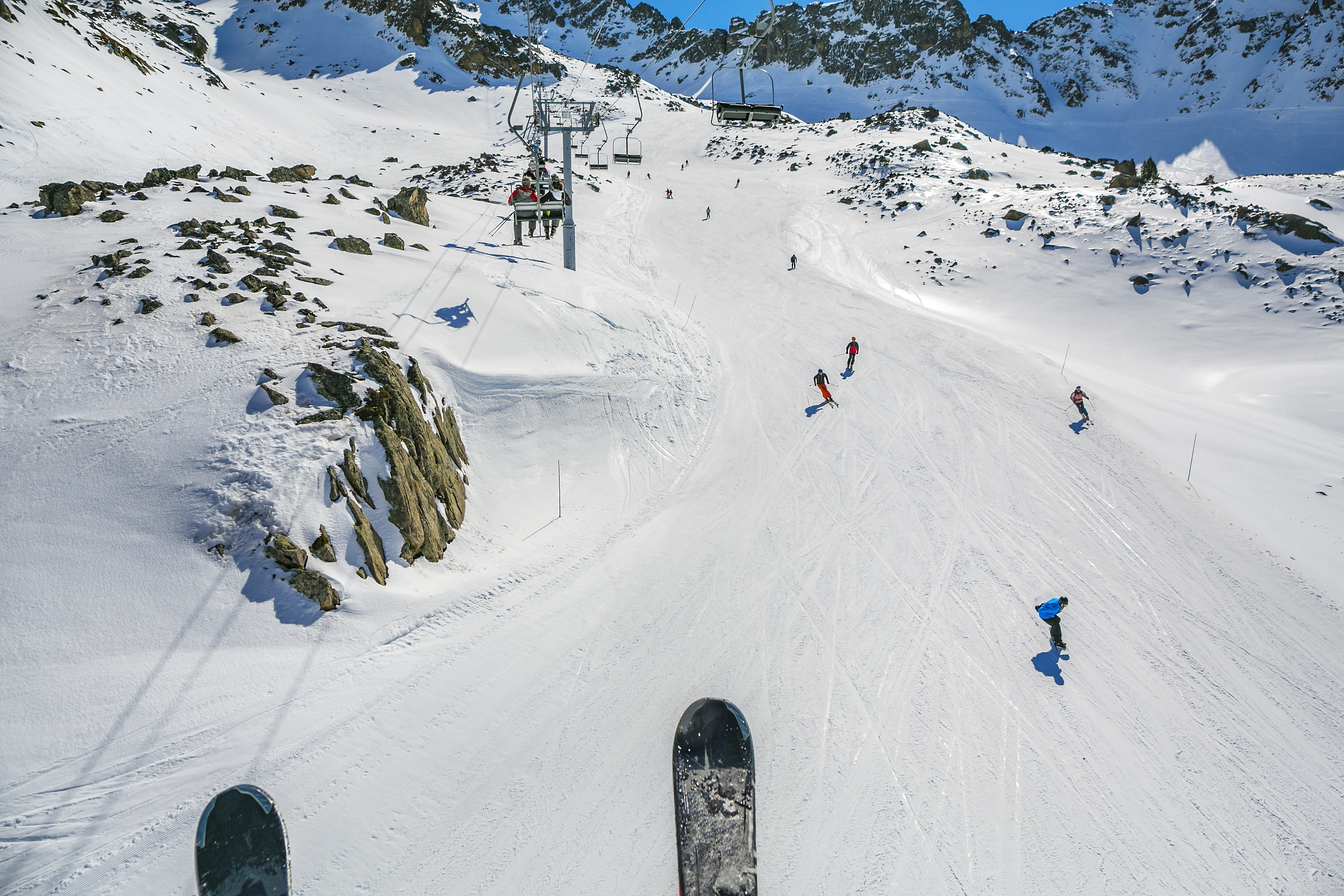 Looking down at other skiers from the ski lift in Grand Tourmalet, France 