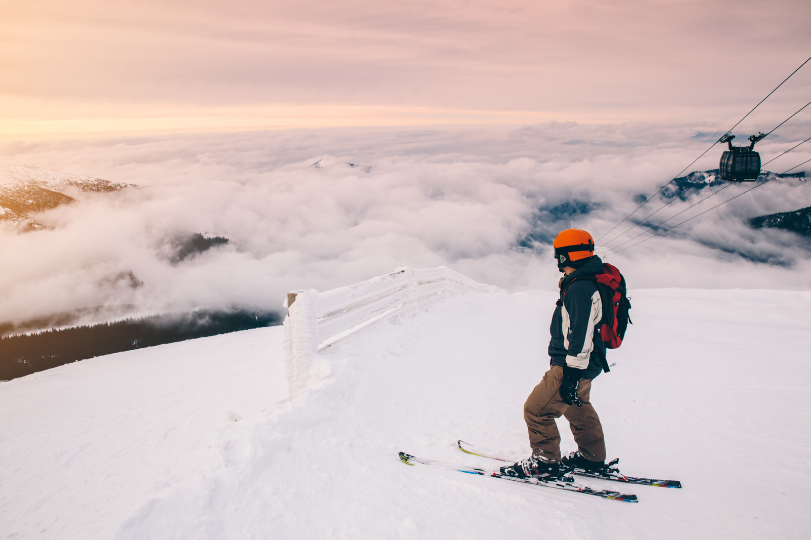 Slovakia Skier at the summit of a mountain in Slovakia; there is cloud cover below and a chairlift rising to the right.