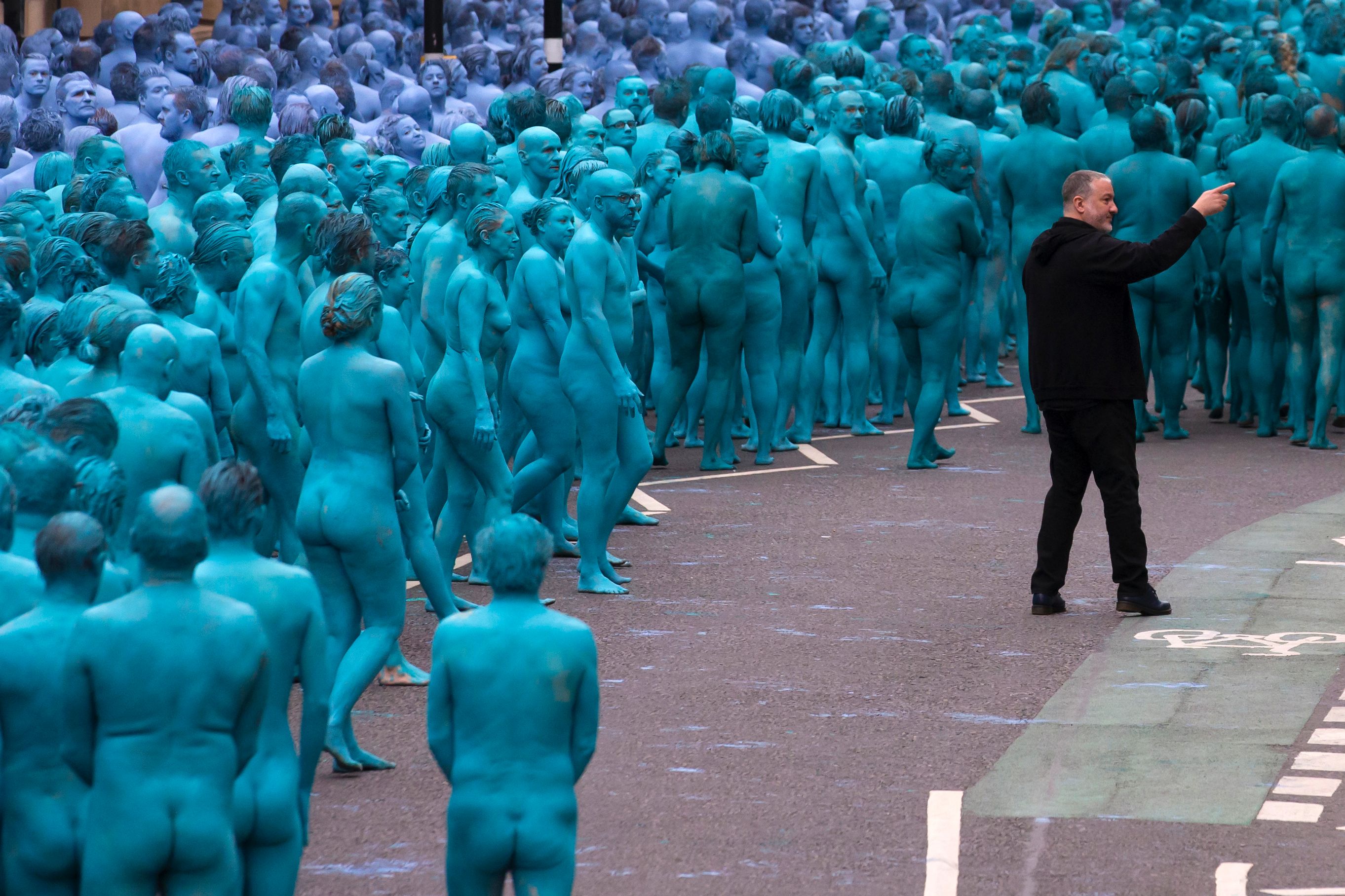 Hundreds of nudist people running into the sea naked