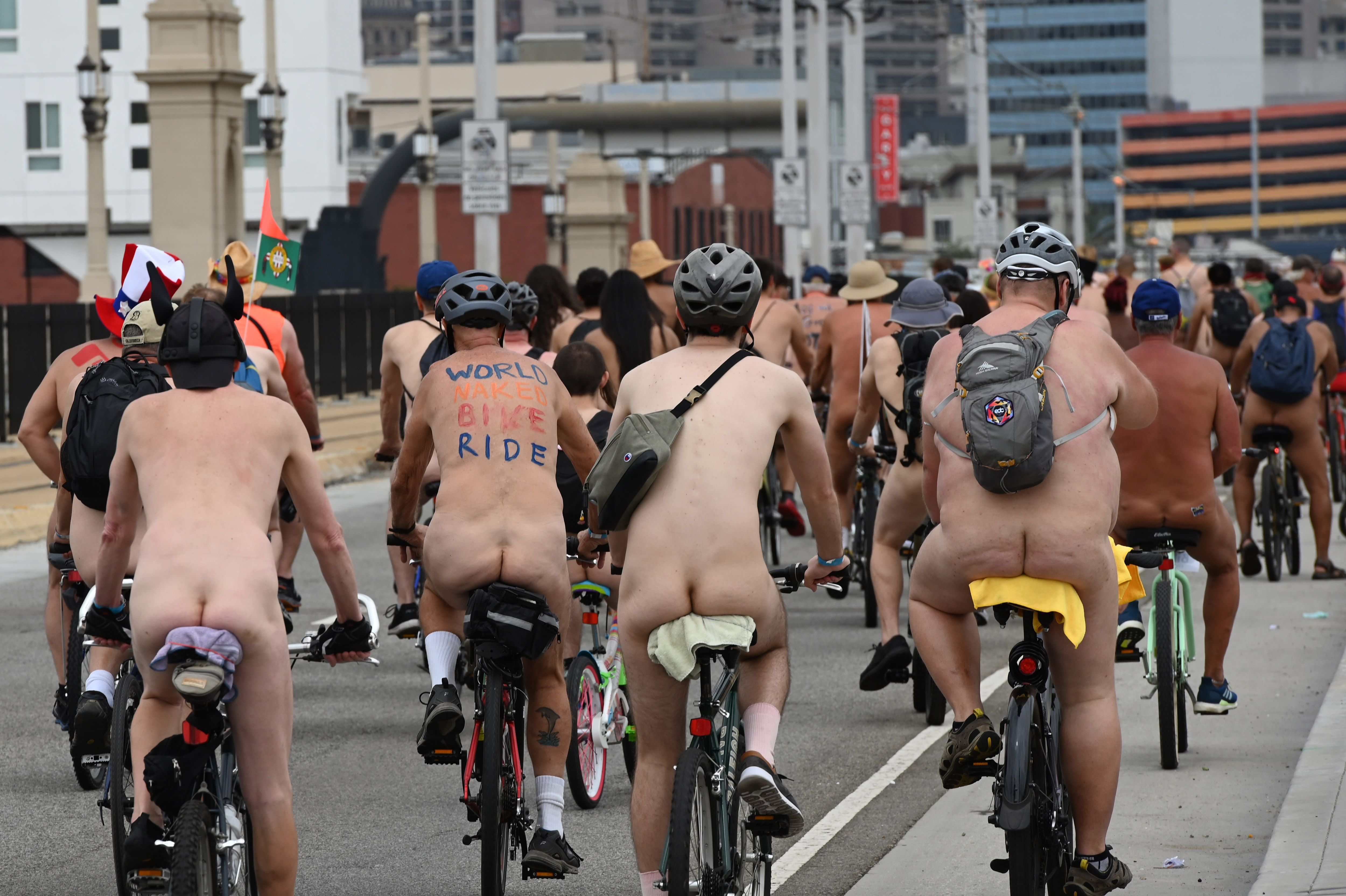 Hundreds of nudist people running into the sea naked